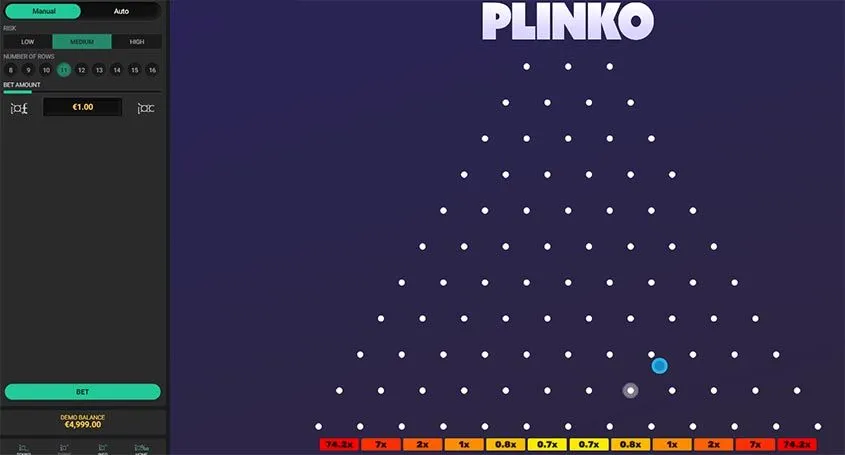 Juego de Plinko con bola azul cayendo; multiplicadores de 0.7x a 74.8x.
